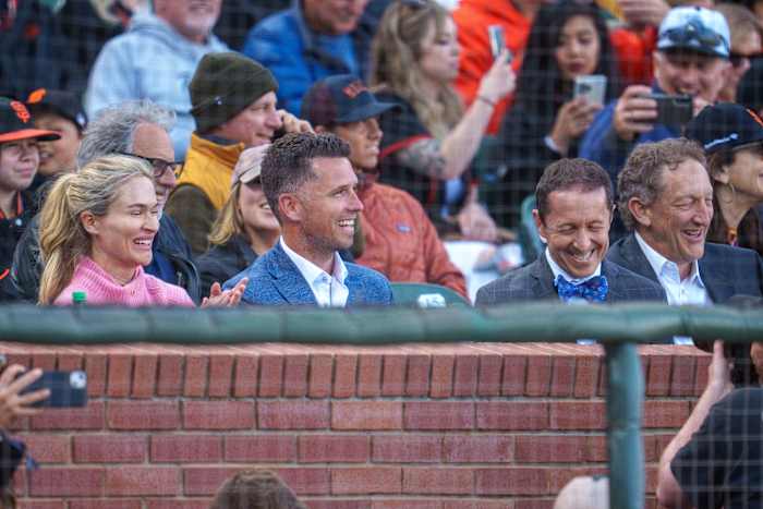 Legendary SF Giants catcher Buster Posey sits in the stands with Kristen Posey (left) and Ken Rosenthal (right).